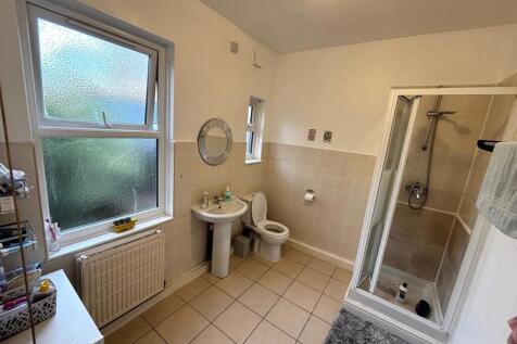 Bright, tiled bathroom with a separate shower c...