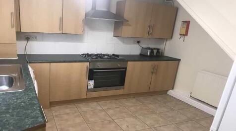 Modern kitchen featuring wooden cabinets, a sta...