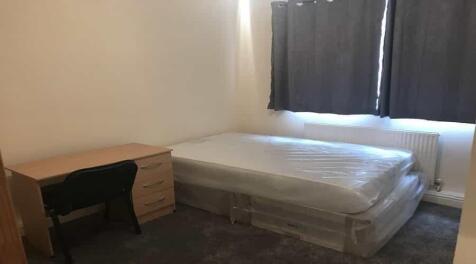 A modest bedroom featuring a double bed with ma...