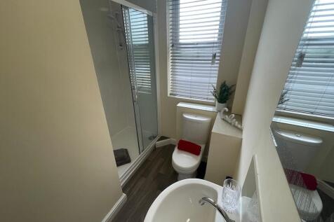 Bright, modern ensuite bathroom featuring a wal...