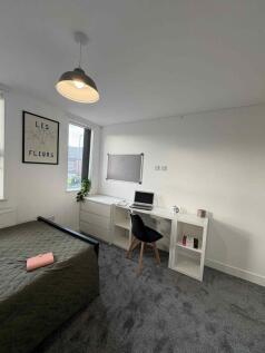 Bright, tidy bedroom with a study area by the w...