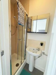 Compact, modern bathroom with a tiled shower cu...