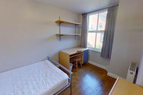 Bright, tidy bedroom with a single bed, wooden ...