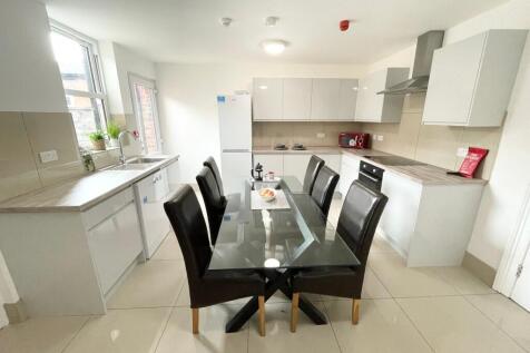 Bright modern kitchen with a central glass dini...