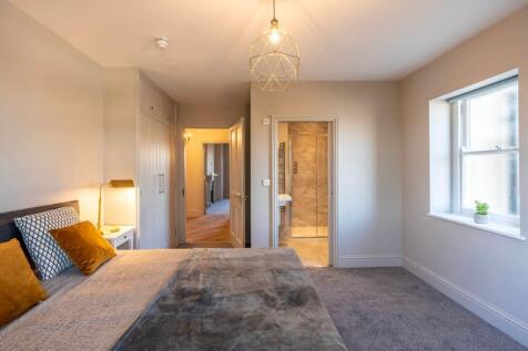 Bright, well-styled master bedroom with a comfo...