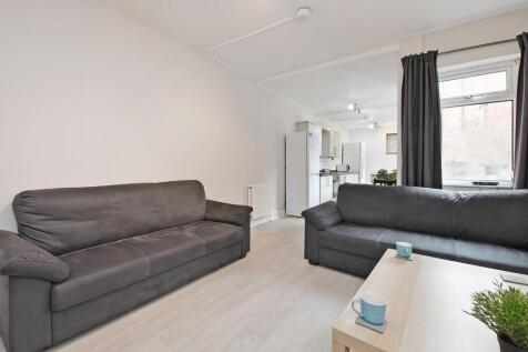 Bright, open-plan living area with two comforta...