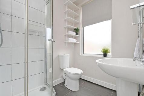 Bright, modern bathroom with a corner shower, w...