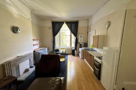 Bright, long open-plan living area with high ce...