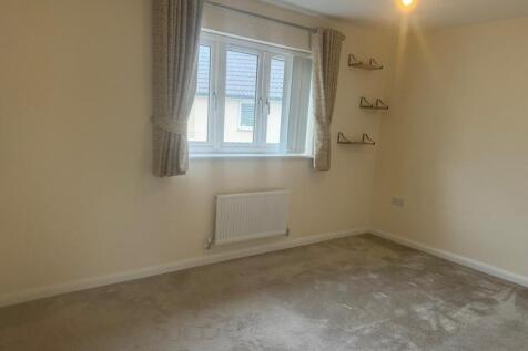 Bright, neutral double bedroom with a large win...
