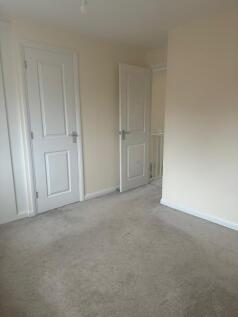 Bright, neutral bedroom with light cream walls,...