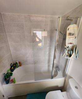 Modern tiled bathroom with a combined bath and ...