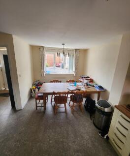 Bright eat-in kitchen with a large wooden dinin...