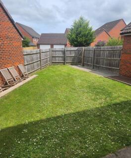 Sunny enclosed rear garden with a well-kept law...