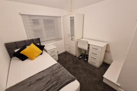 Bright, neatly furnished single bedroom with a ...