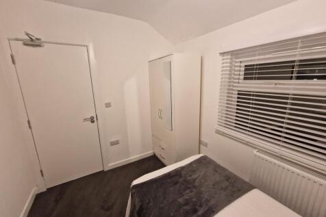 Neat, simply furnished bedroom with a comfortab...