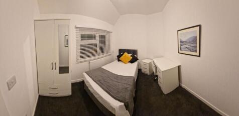 Bright, neatly furnished bedroom with a comfort...