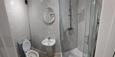 Bright, modern bathroom with a glass corner sho...