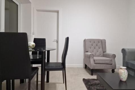 Bright, modern living area with a glass dining ...