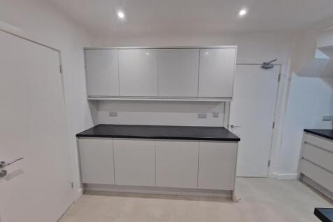 Modern, minimal kitchen with sleek grey cabinet...