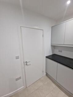 Bright modern kitchen area with sleek grey cabi...