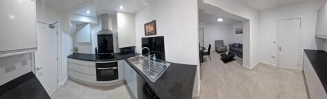 Bright modern kitchen with sleek black countert...