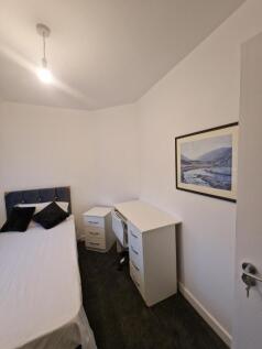 Neat, simply furnished double bedroom with a co...