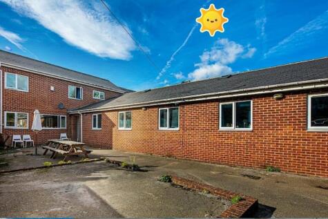 Sunny brick courtyard with outdoor seating and ...