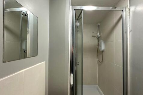 Compact modern bathroom with a tiled walk-in sh...