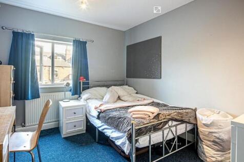 Bright, simply furnished bedroom with a metal b...