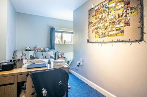 Bright, neatly arranged bedroom with a study de...