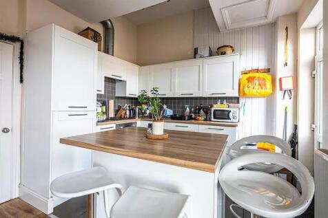 Bright and modern kitchen featuring white cabin...