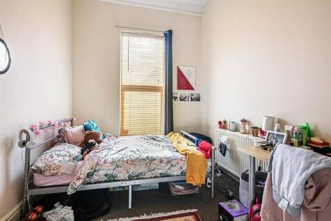 Cozy single bedroom featuring a comfortable bed...