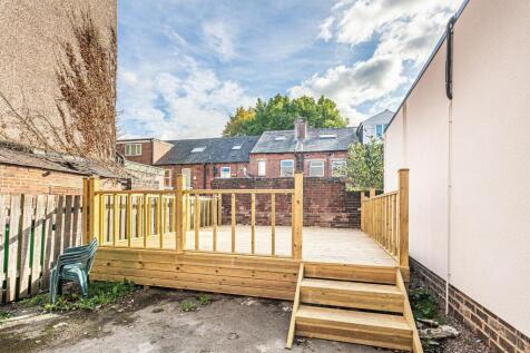 Bright raised wooden deck with new railing and ...