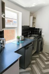 Bright compact kitchen with a large window, mod...