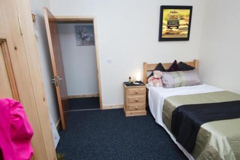 Neat, simply furnished single bedroom with a co...