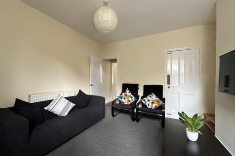 Bright, neatly presented living room with a com...