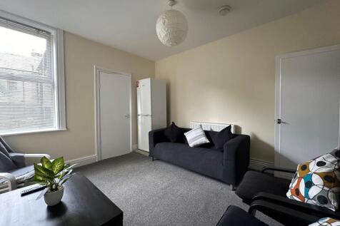 Bright, neutrally decorated living area with co...