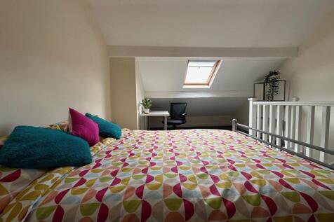 Bright attic double bedroom with patterned bedd...