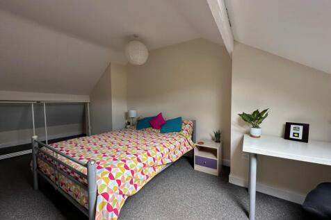 Bright, neatly styled bedroom in a loft room wi...