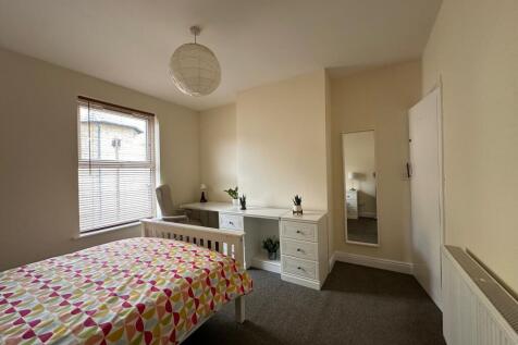 Bright, neutrally decorated double bedroom with...