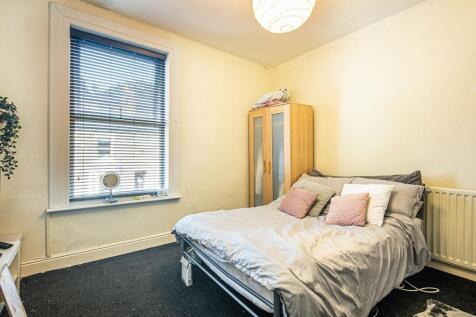 Bright double bedroom with a large sash window ...