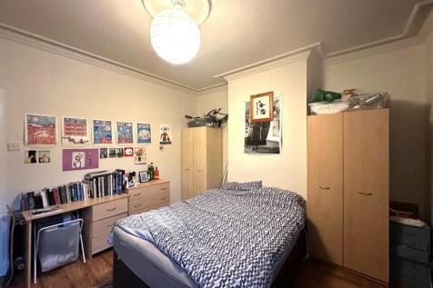 Bright, neatly arranged double bedroom with a d...