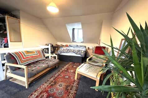 Bright attic double bedroom with a central bed ...