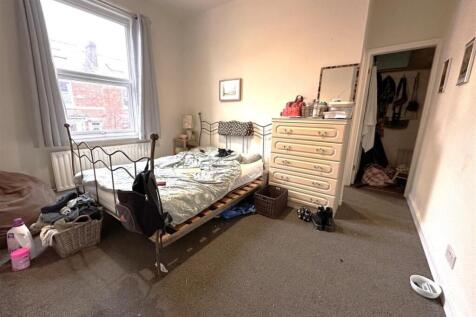 Bright double bedroom with a large sash window ...