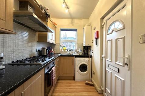 Bright galley kitchen with modern appliances, g...