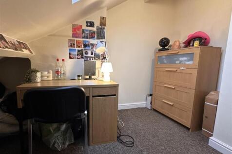 Cozy attic bedroom corner with a study desk, la...