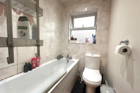 Bright tiled bathroom with a modern white batht...