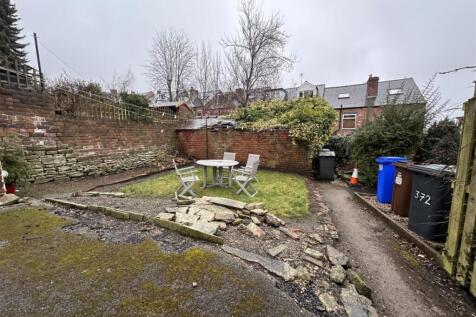 Enclosed rear garden with a small lawned seatin...