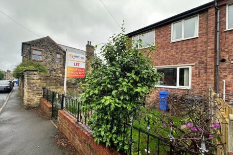 Brick-fronted terraced house with a small fence...