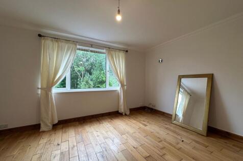 Bright, freshly painted bedroom with large wind...